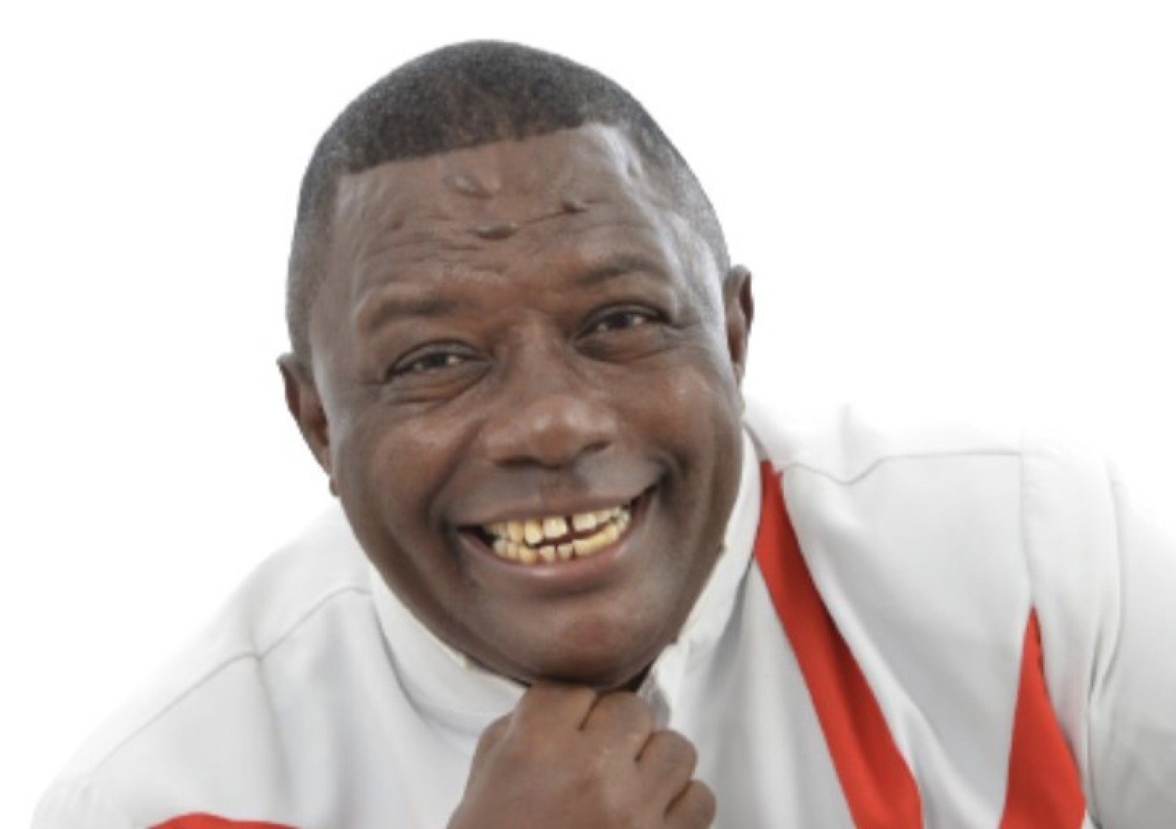 M&uacute;sico Fabinho do Terreiro usa camisa branca e sorri para a c&acirc;mera com o queixo na m&atilde;o