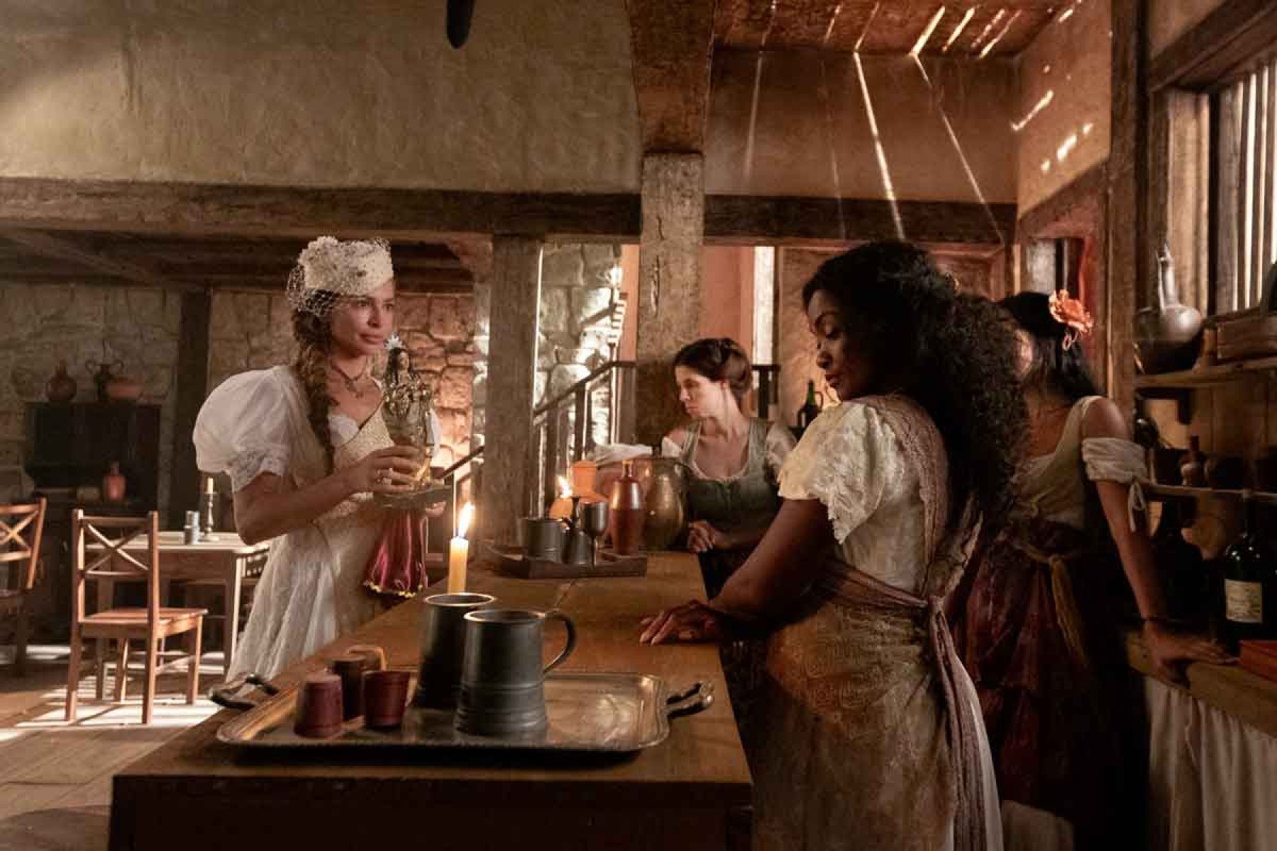 Atriz Grazi Massafera segura imagem de santa e mostra &agrave; atriz Erika Januza, numa venda de interior, em cena da novela Dona Beja 