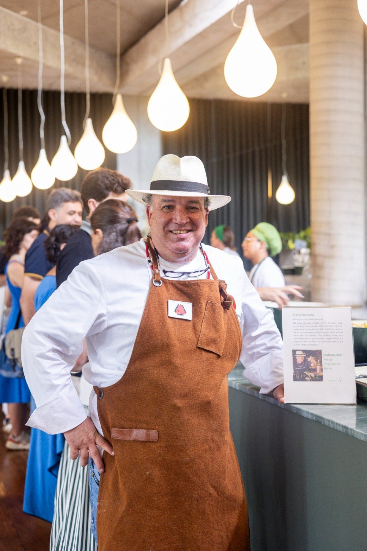 Chef do Xapuri, Fl&aacute;vio Trombino posa, com orgulho, ao lado da placa que conta sua hist&oacute;ria e a do prato que escolheu levar para o Inhotim