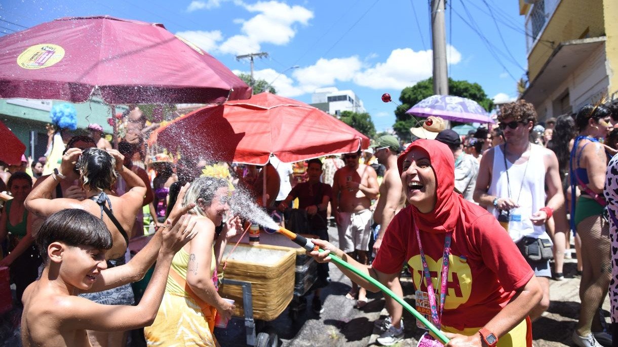 Manter-se hidratado &eacute; essencial para aproveitar a folia: foli&otilde;es se refrescam em bloco de Carnaval com jatos de &aacute;gua -  (crédito: Gladyston Rodrigues/EM/D.A. Press)
