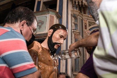  Na quarta-feira de cinzas, homens dão banho de cachaça na imagem de Cristo em Morro Vermelho, distrito de Caeté -  (crédito: Jorge Lopes/EM)