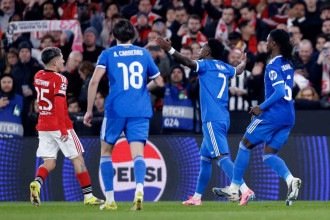 Gianluca Prestianni, do Benfica (E), questiona Vini Jr (C), do Real Madrid, no jogo no Estádio da Luz, pela Liga dos Campeões -  (crédito: FILIPE AMORIM / AFP)