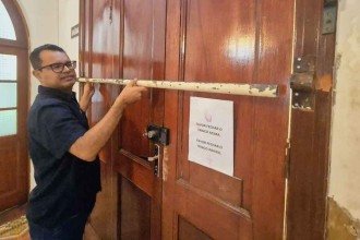 Padre José Júnior mostra barra de ferro colocada em porta lateral do santuário depois de invasão -  (crédito:  Jair Amaral/EM/D.A Press)