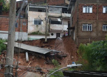 No bairro Jardim Natal, em Juiz de Fora, seis resid&ecirc;ncias foram invadidas pela enchente. Pessoas limpam suas casas, removem m&oacute;veis e utens&iacute;lios, m&aacute;quinas tentam desobstruir o leito do c&oacute;rrego que est&aacute; repleto de destro&ccedil;os -  (crédito: T&uacute;lio Santos/EM/D.A Press)