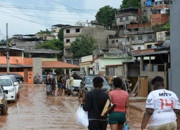 No bairro Jardim Natal, em Juiz de Fora, seis residências foram invadidas pela enchente. Pessoas limpam suas casas, removem móveis e utensílios, máquinas tentam desobstruir o leito do córrego que está repleto de destroços -  (crédito: Túlio Santos/EM/D.A Press)