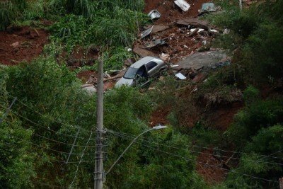 No bairro Jardim Natal, em Juiz de Fora, seis residências foram invadidas pela enchente. Pessoas limpam suas casas, removem móveis e utensílios, máquinas tentam desobstruir o leito do córrego que está repleto de destroços -  (crédito: Túlio Santos/EM/D.A Press)