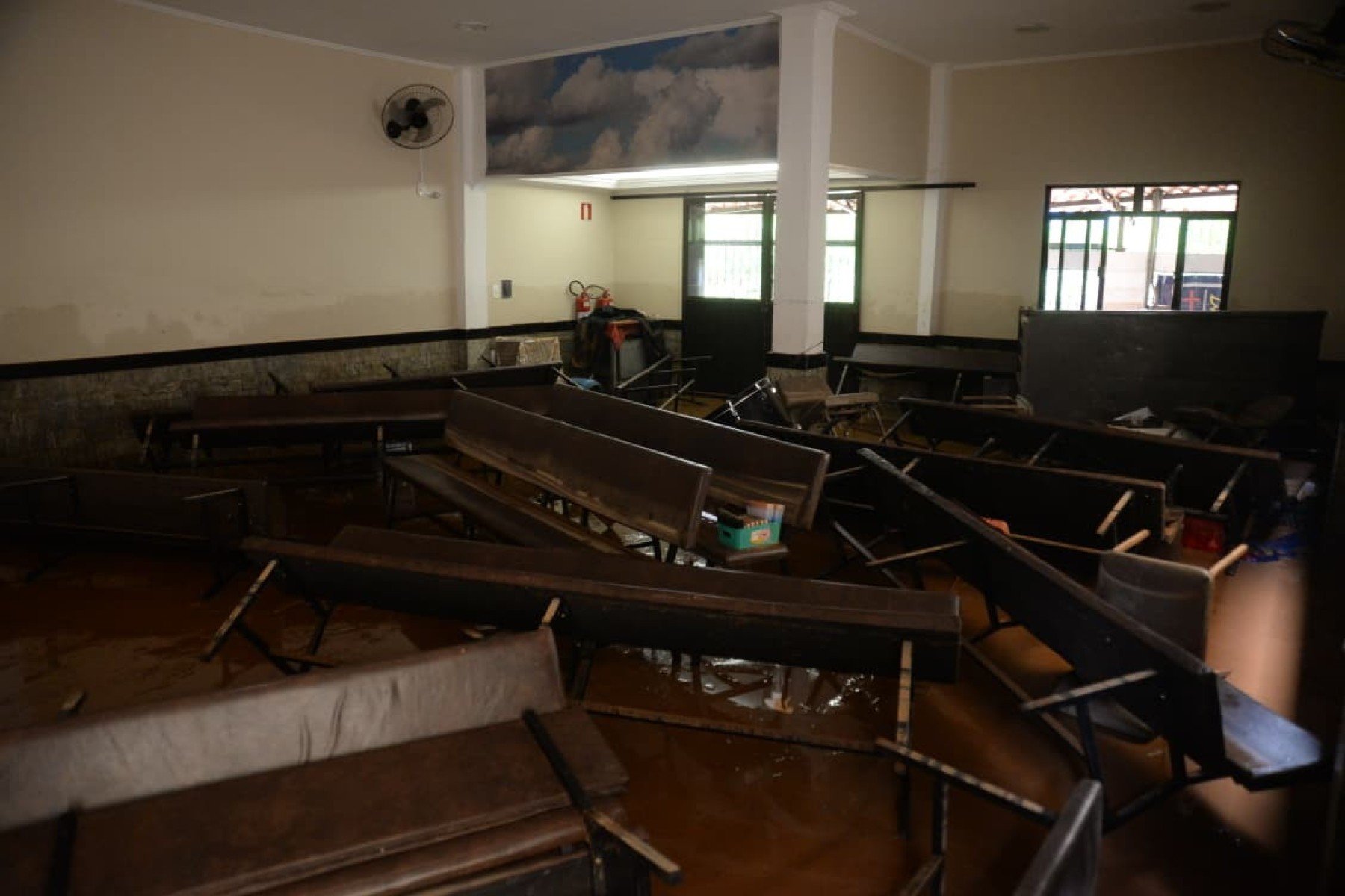 No bairro Jardim Natal, em Juiz de Fora, seis residências foram invadidas pela enchente. Pessoas limpam suas casas, removem móveis e utensílios, máquinas tentam desobstruir o leito do córrego que está repleto de destroços