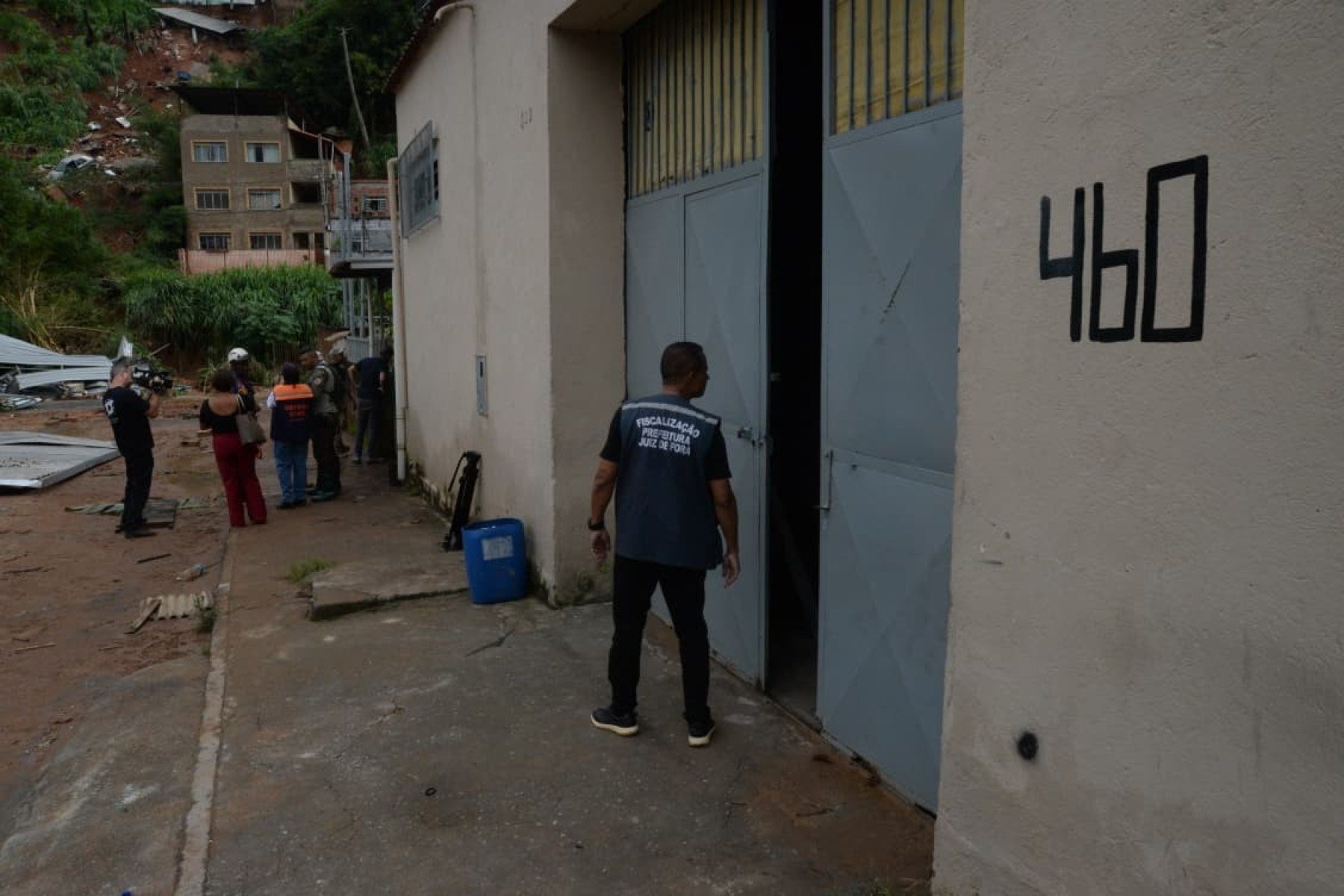 No bairro Jardim Natal, em Juiz de Fora, seis residências foram invadidas pela enchente. Pessoas limpam suas casas, removem móveis e utensílios, máquinas tentam desobstruir o leito do córrego que está repleto de destroços