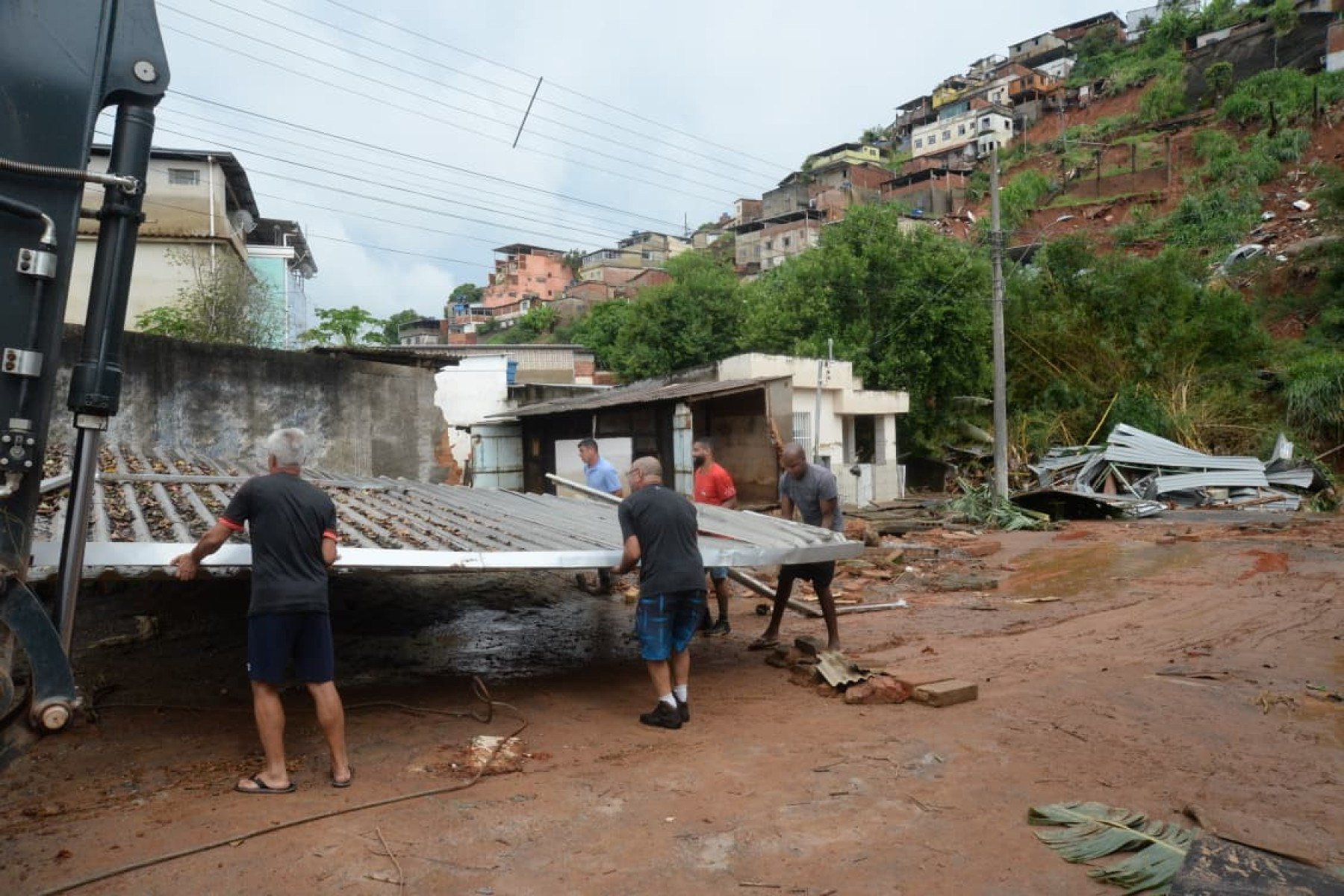 No bairro Jardim Natal, em Juiz de Fora, seis residências foram invadidas pela enchente. Pessoas limpam suas casas, removem móveis e utensílios, máquinas tentam desobstruir o leito do córrego que está repleto de destroços