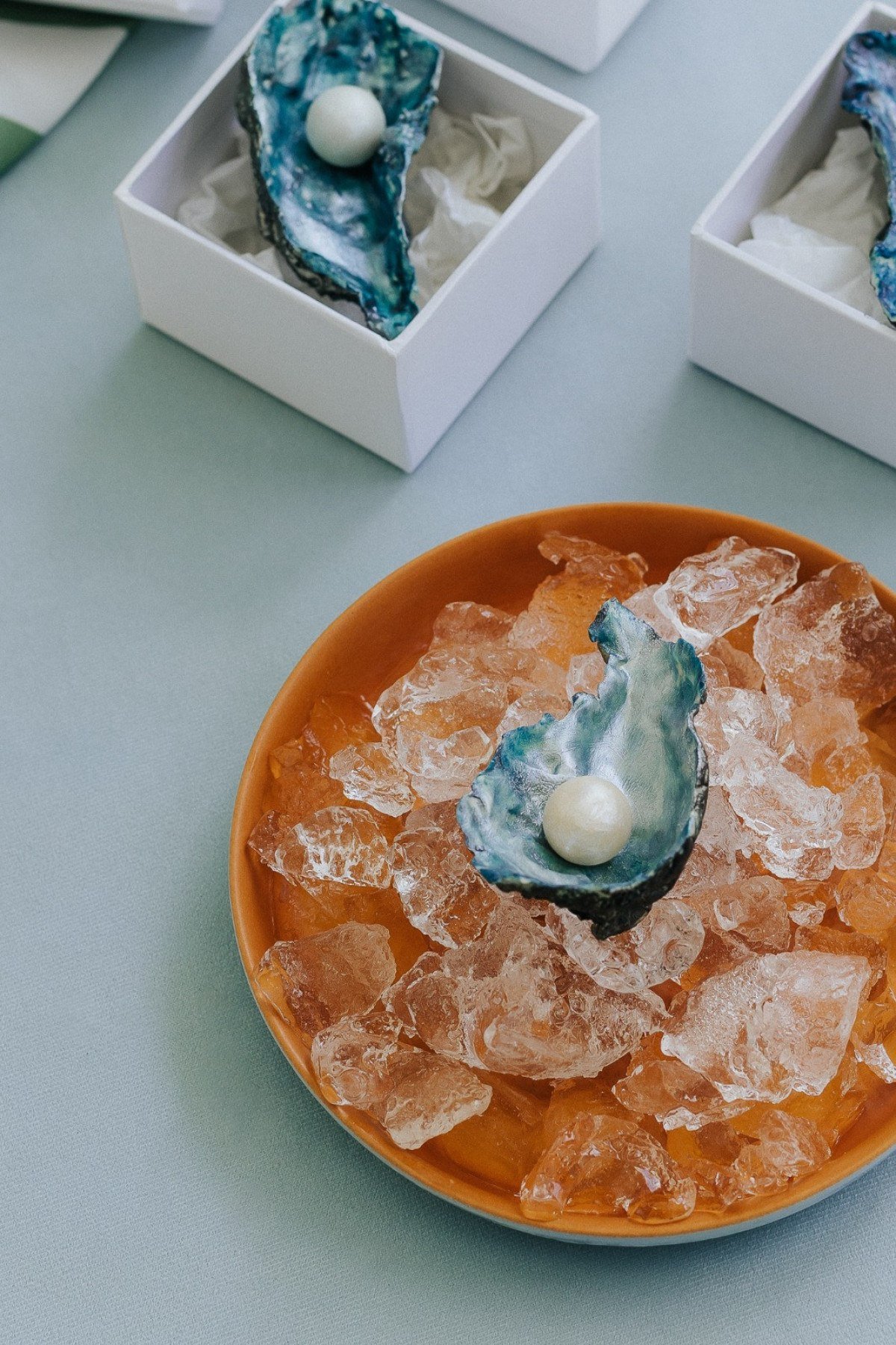 Dentro da concha de chocolate de maracuj&aacute;, reluz uma 'p&eacute;rola', que nada mais &eacute; que uma trufa de avel&atilde; com coco caramelizado