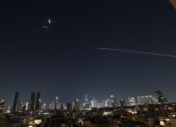 Rastros de foguetes são vistos no céu em meio a uma nova série de ataques com mísseis iranianos sobre a cidade costeira israelense de Tel Aviv -  (crédito:  Jack GUEZ/AFP)