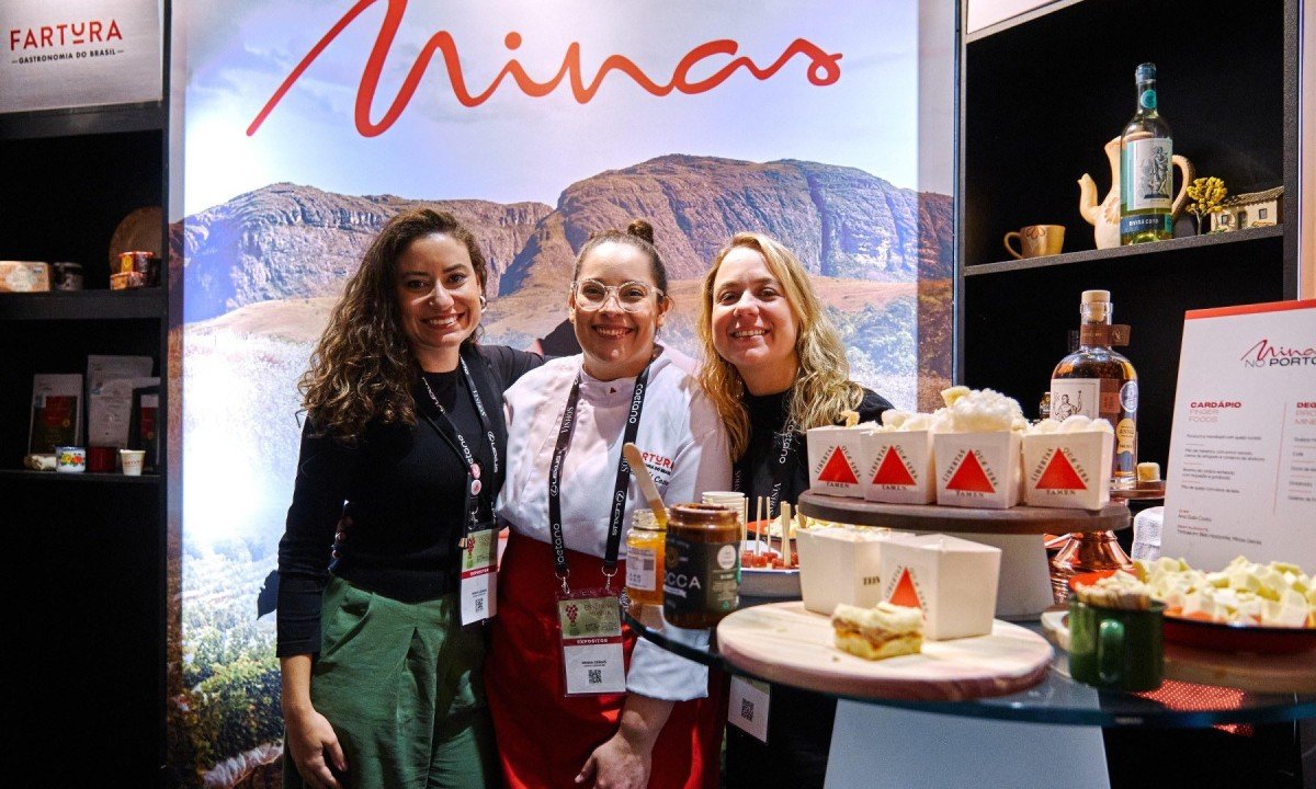 A chef Ana Gabi Costa (ao centro) com Ana Lu&iacute;sa Macedo e Ananda Fernandes, produtoras da Plataforma Fartura. As tr&ecirc;s est&atilde;o lado a lado, em estande de feira gastron&ocirc;mica em Portugal, sorrindo para a c&acirc;mera