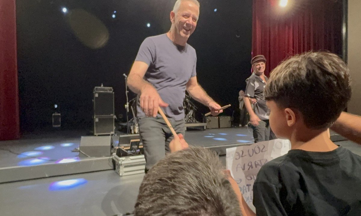 Baterista Jo&atilde;o Barone est&aacute; no palco e entrega baquetas do show em BH para o f&atilde; Pedrinho, de 4 anos