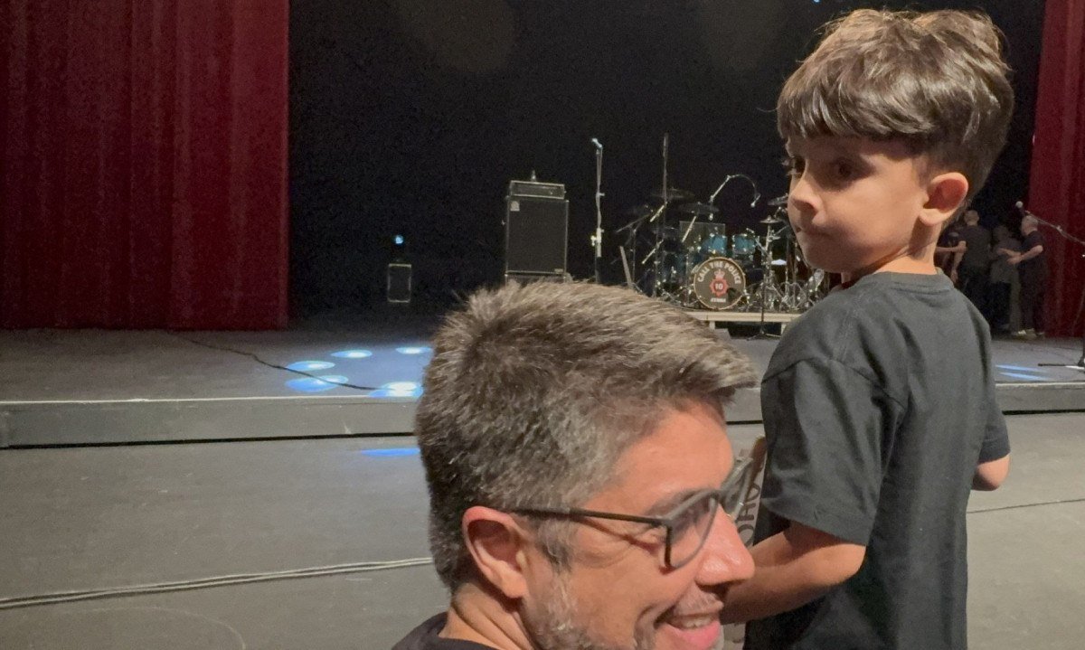 Pedro Chaves, de 4 anos, ficou pertinho do palco do Pal&aacute;cio das Artes e segura cartaz onde pede as baquetas do baterista Jo&atilde;o Barone