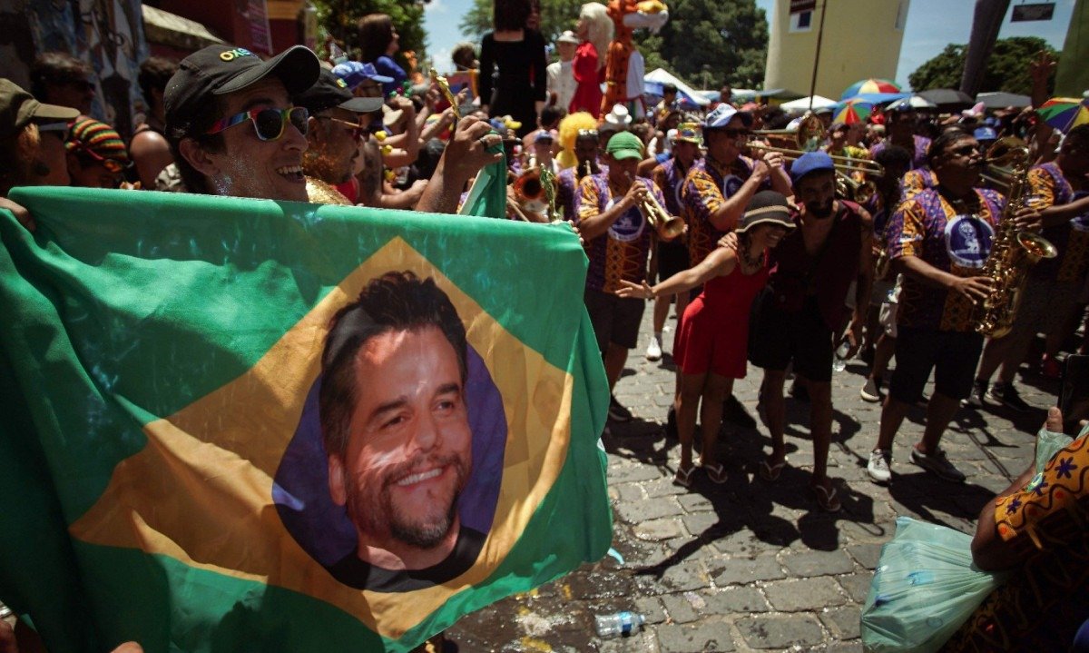 Rosto do ator Wagner Moura, no filme O agente secreto, est&aacute; no centro da Bandeira do Brasil levada por foli&otilde;es do bloco Pitombeira, no carnaval do Recife