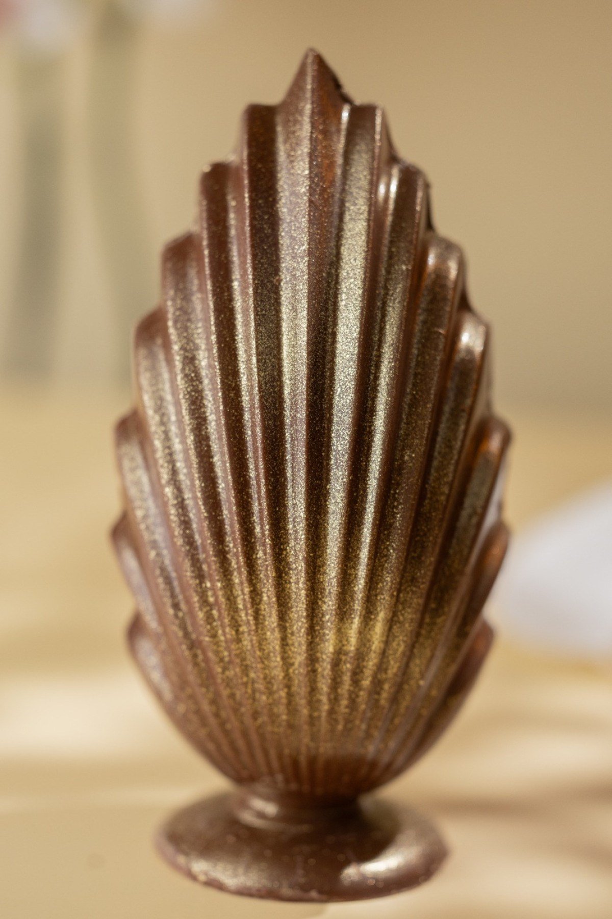 O ovo de chocolate ao leite com decora&ccedil;&atilde;o dourada da Turci &eacute; moldado em uma forma que lembra uma concha