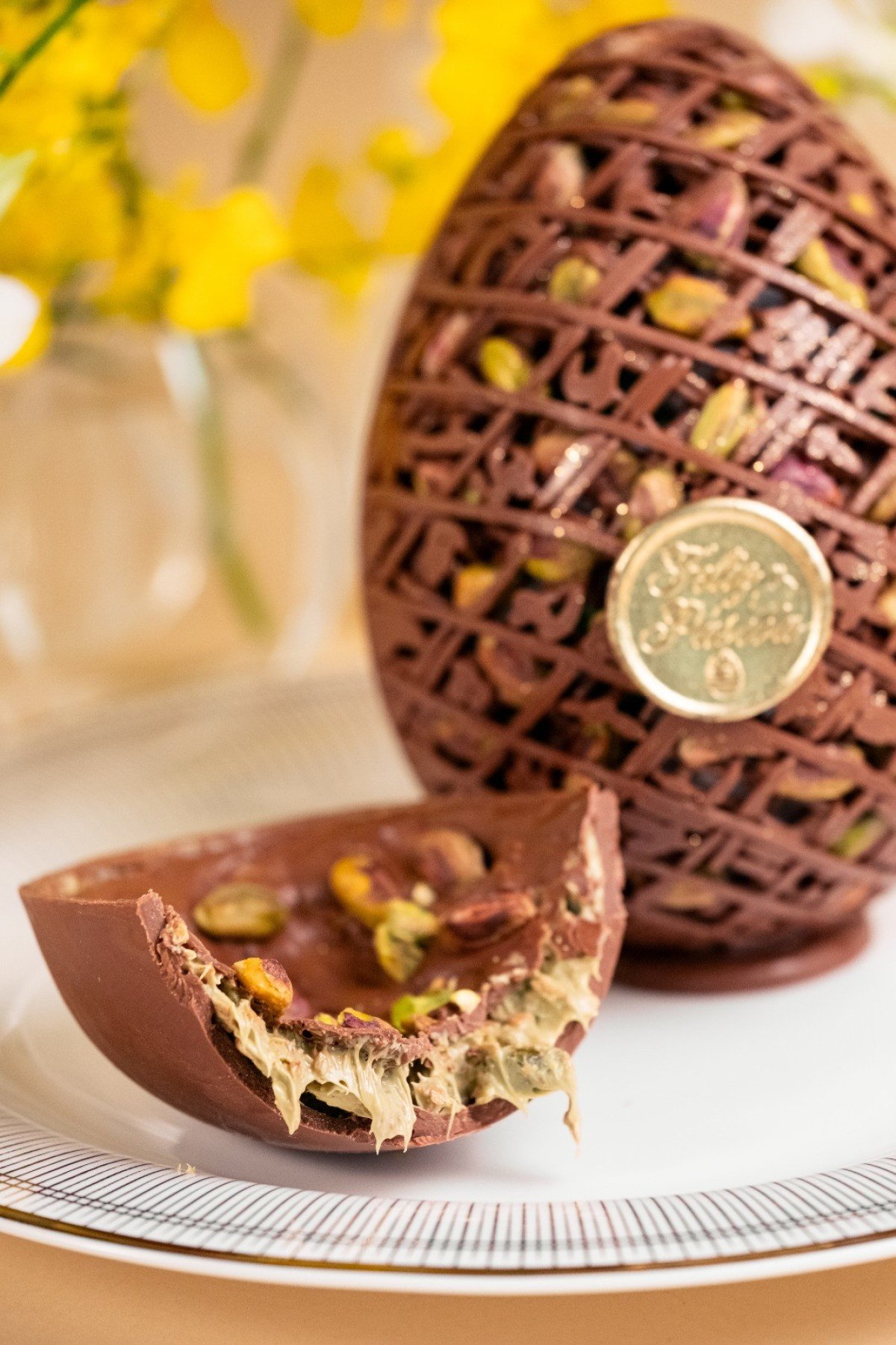 Por dentro da 'treli&ccedil;a' de chocolate da Confiserie by Cynthia Geo, encontramos um recheio cremoso e crocante de pistache e massa folhada