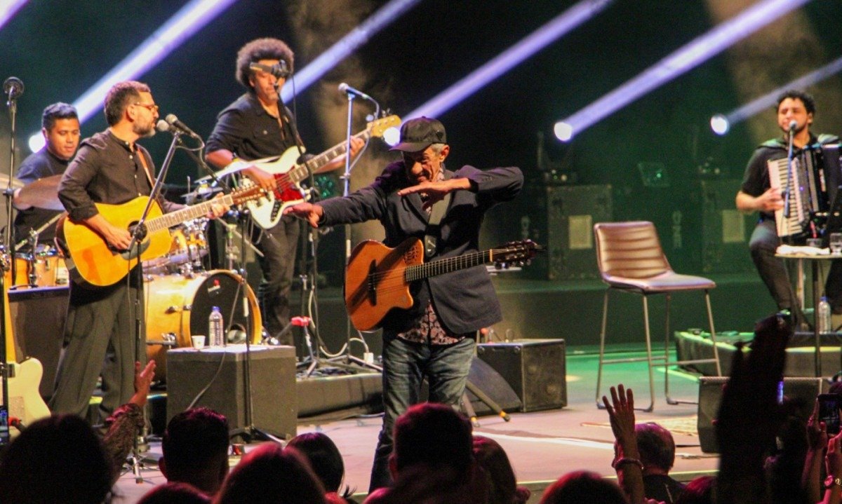 Fagner brinca com o p&uacute;blico durante show no Pal&aacute;cio das Artes. Ele est&aacute; no palco com a banda e gesticula  com os bra&ccedil;os para f&atilde;, que est&aacute; na fila do gargarejo
