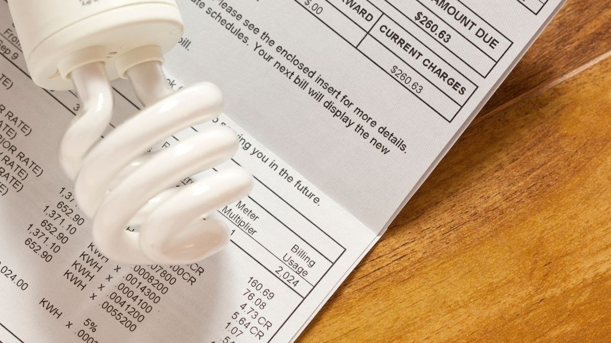 Uma l&acirc;mpada fluorescente compacta sobre uma conta de energia, refor&ccedil;ando a import&acirc;ncia de h&aacute;bitos para reduzir o consumo el&eacute;trico. -  (crédito: Kameleon007 de Getty Images Signature)