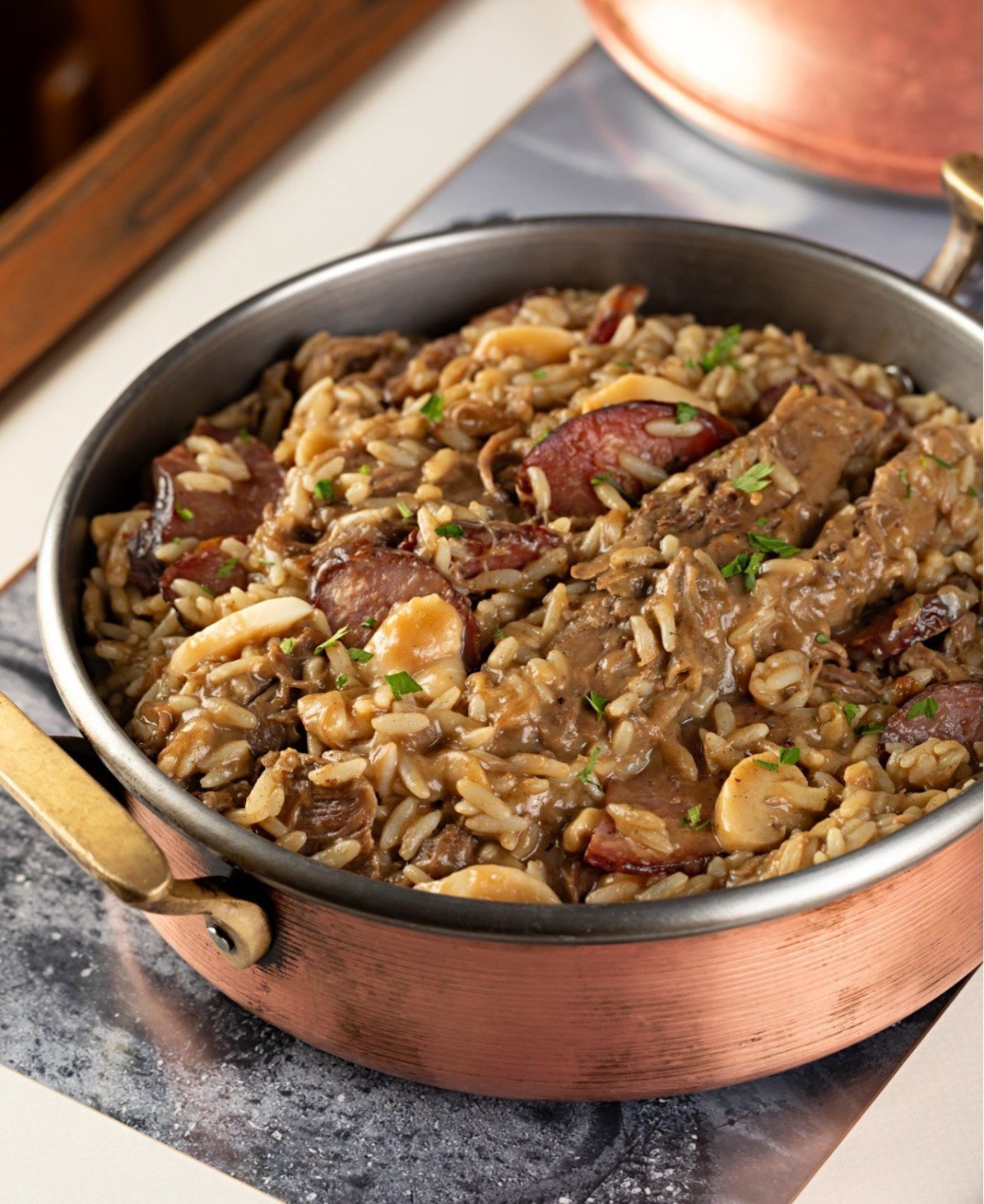 Rancho Portugu&ecirc;s: arroz arb&oacute;reo, paleta de cabrito desfiada, paio e cogumelos salteados 