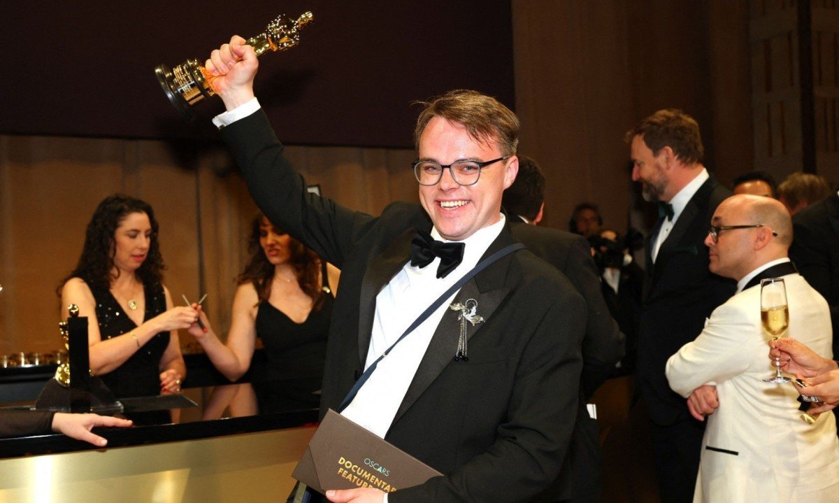 O russo Pavel Talankin sorri e ergue o Oscar que ganhou pelo document&aacute;rio Um Z&eacute; Ningu&eacute;m contra Putin