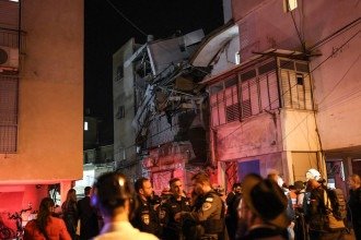 Forças de segurança e equipes de resgate se reúnem ao lado de um prédio danificado em um local atingido por um projétil em Bnei Brak, nos arredores de Tel Aviv, em 24 de março de 2026 -  (crédito: ILIA YEFIMOVICH / AFP)