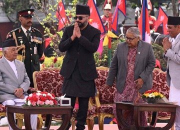 Recém-empossado primeiro-ministro do Nepal, Balendra Shah (C), gesticula enquanto a ex-primeira-ministra interina Sushila Karki (2ª à direita) e o presidente Ram Chandra Paudel (à esquerda) observam durante a cerimônia de posse em Katmandu, em 27 de março de 2026 -  (crédito: PRAKASH MATHEMA / AFP)