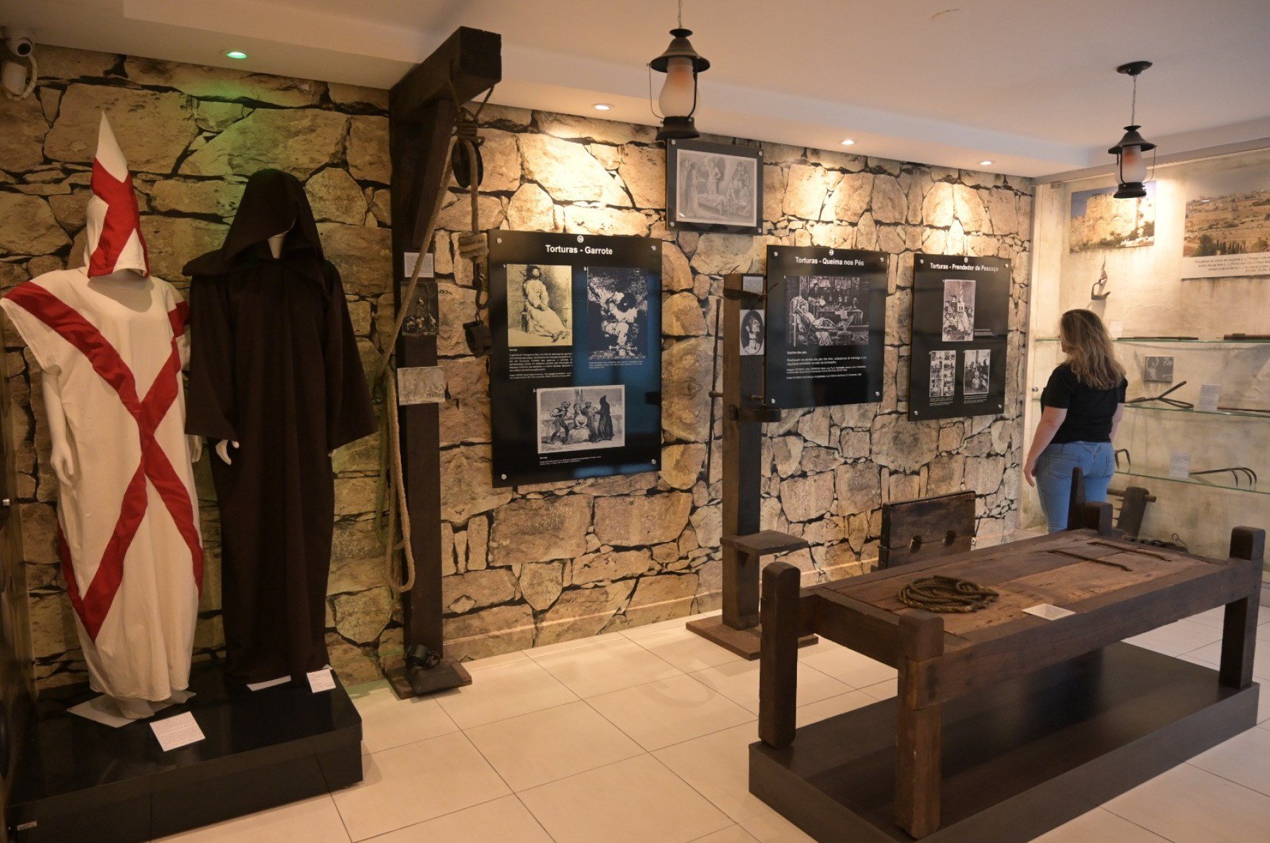 A exposi&ccedil;&atilde;o tamb&eacute;m re&uacute;ne r&eacute;plicas de instrumentos de tortura e execu&ccedil;&atilde;o utilizados na &eacute;poca, como o pol&eacute; e o garrote, que ilustram os m&eacute;todos empregados na obten&ccedil;&atilde;o de confiss&otilde;es e na aplica&ccedil;&atilde;o da pena de morte