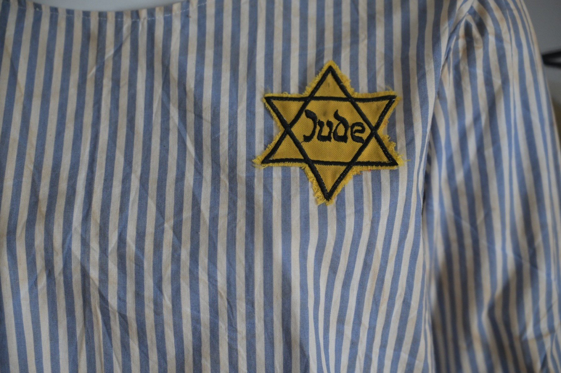 Roupa usada por judeus em campo de concentra&ccedil;&atilde;o, com a estrela de Davi em amarelo e palavra 'Jude' no centro