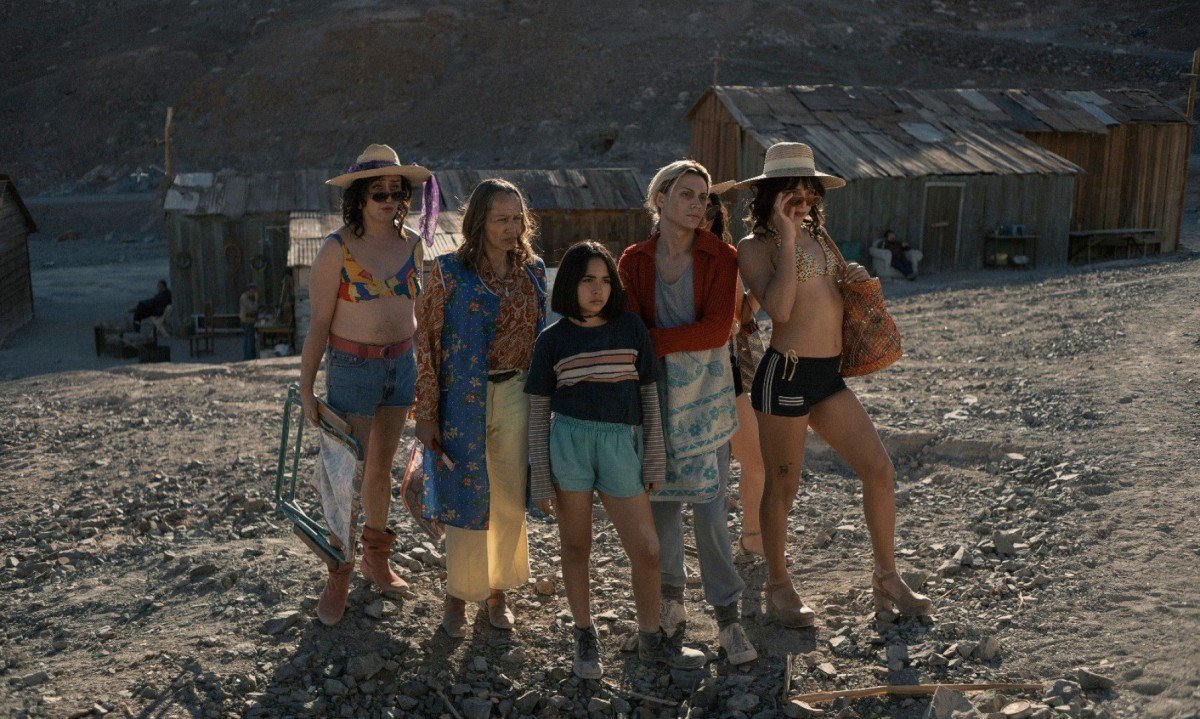 A jovem atriz Tamara Cort&eacute;s est&aacute; &agrave; frente de quatro atrizes trans, em frente a casebre no deserto de Atacama, na cena do filme O olhar misterioso do flamingo