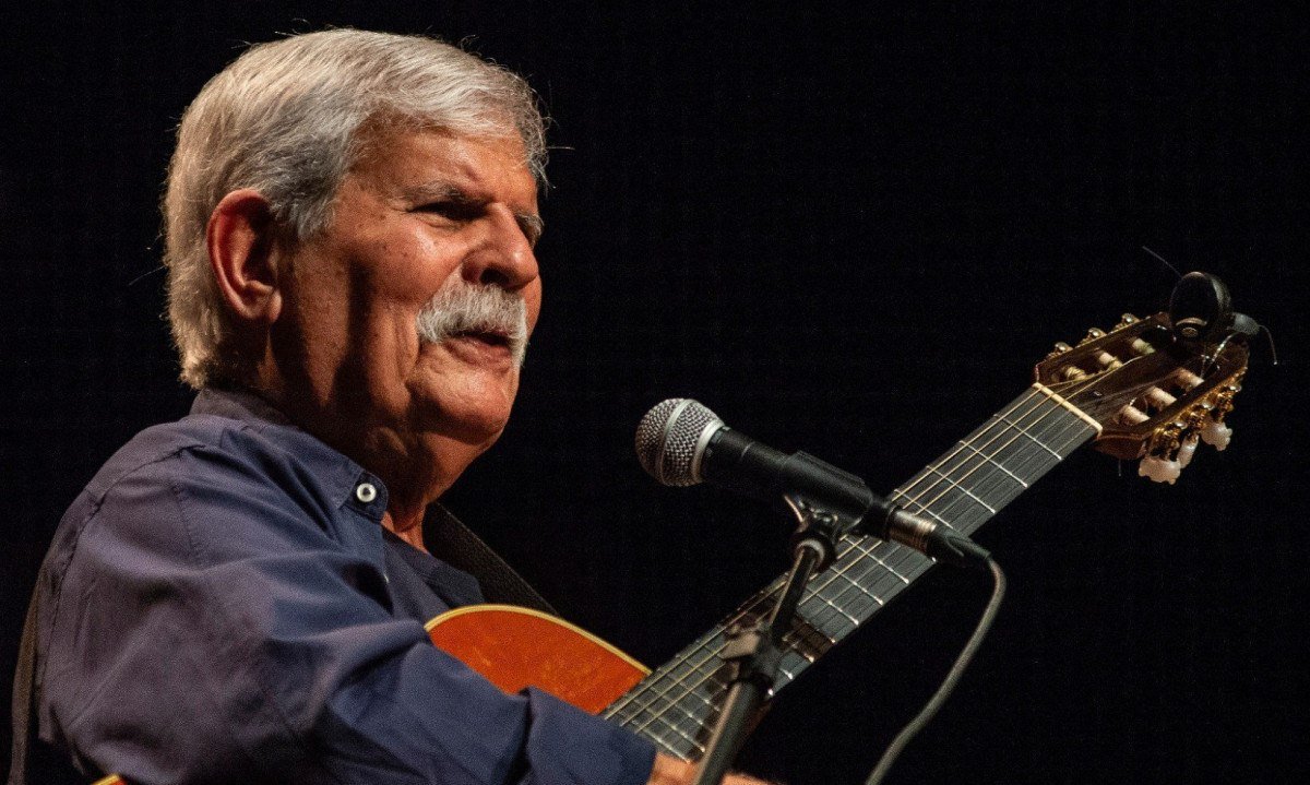 Dori Caymmi fala ao microfone e segura o viol&atilde;o durante show em BH