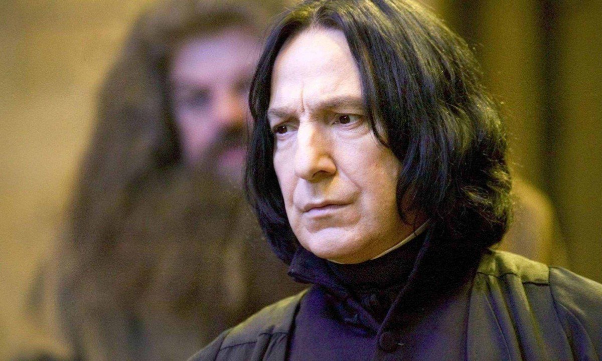 Ator Alan Rickman com longos cabelos pretos em filme da saga Harry Potter