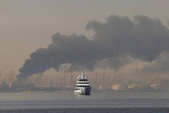 Iate navega no porto de Dubai, nos Emirados Árabes Unidos, após ataque iraniano deixar coluna de fumaça nos céus  -  (crédito: Fadel Senna - 1.mar.26/AFP)
