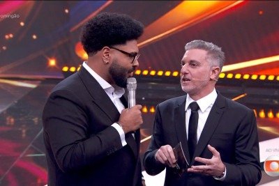 Luciano Huck cometeu uma gafe durante a apresentação do “Melhores do Ano de 2025”, que aconteceu no dia 29 de março de 2026. O apresentador se confundiu ao querer mencionar a “série dos bicheiros” e citou “Os Donos do Jogo”, da Netflix, em vez de citar “Vale o Escrito”, da Globoplay. Na hora, o humorista Paulo Vieira corrigiu o amigo e disse que a série que ele havia mencionado era da concorrência.
 -  (crédito: Reprodução TV Globo)