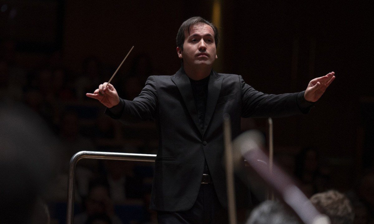 Maestro Jos&eacute; Soares tem os bra&ccedil;os abertos enquanto rege a Sinf&ocirc;nica de Minas