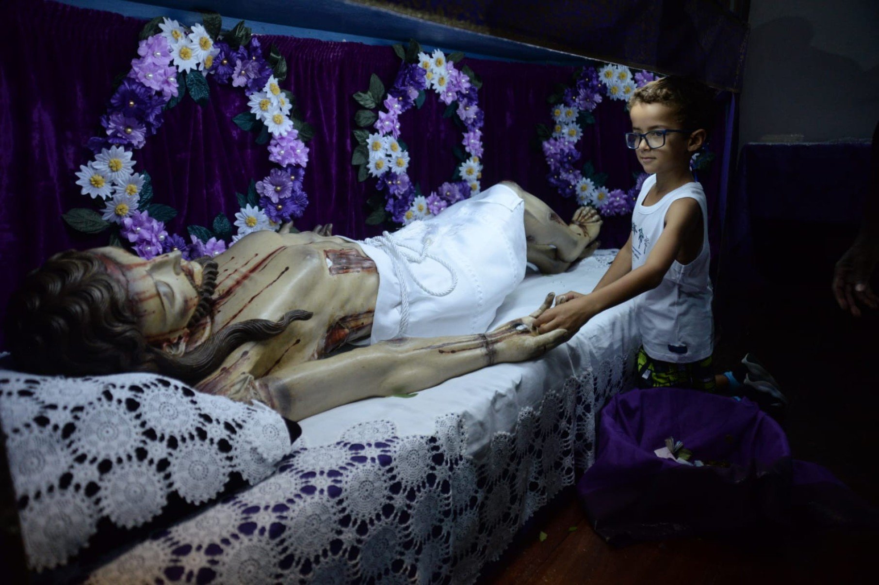 Ao se ajoelhar diante do esquife de Jesus, para uma breve oração ou tocar a imagem, o fiel mantém um velho costume: trocar uma moedinha por outra