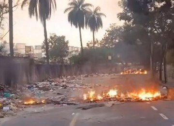 O lixo se encontra espalhado pela via. Cansados da situação, os moradores incendiaram os resíduos. -  (crédito: Redes Sociais/Reprodução)