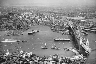 Sidney respira história e modernidade, e nada simboliza melhor essa união do que a Ponte da Baía da cidade, inaugurada em 19 de março de 1932. Ao completar 94 anos, ela nos convida a revisitar não apenas sua grandiosa engenharia, mas a trajetória da cidade que cresceu ao seu redor, tornando-se um dos destinos mais vibrantes do mundo. -  (crédito: National Library of Australia/Wikimédia Commons)