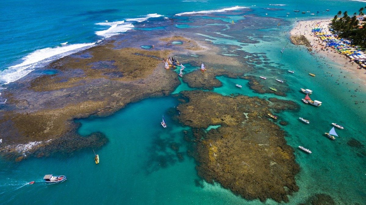 As piscinas naturais de Porto de Galinhas, repletas de jangadas e turistas, s&atilde;o um dos principais atrativos do destino. -  (crédito: Ildo Frazao de Getty Images)