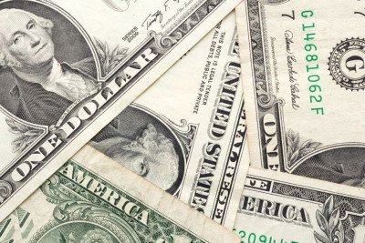 Notas de d&oacute;lar americano refletem a moeda central da economia global, cuja cota&ccedil;&atilde;o di&aacute;ria impacta mercados e o seu bolso. -  (crédito: yalcinadali de Getty Images)