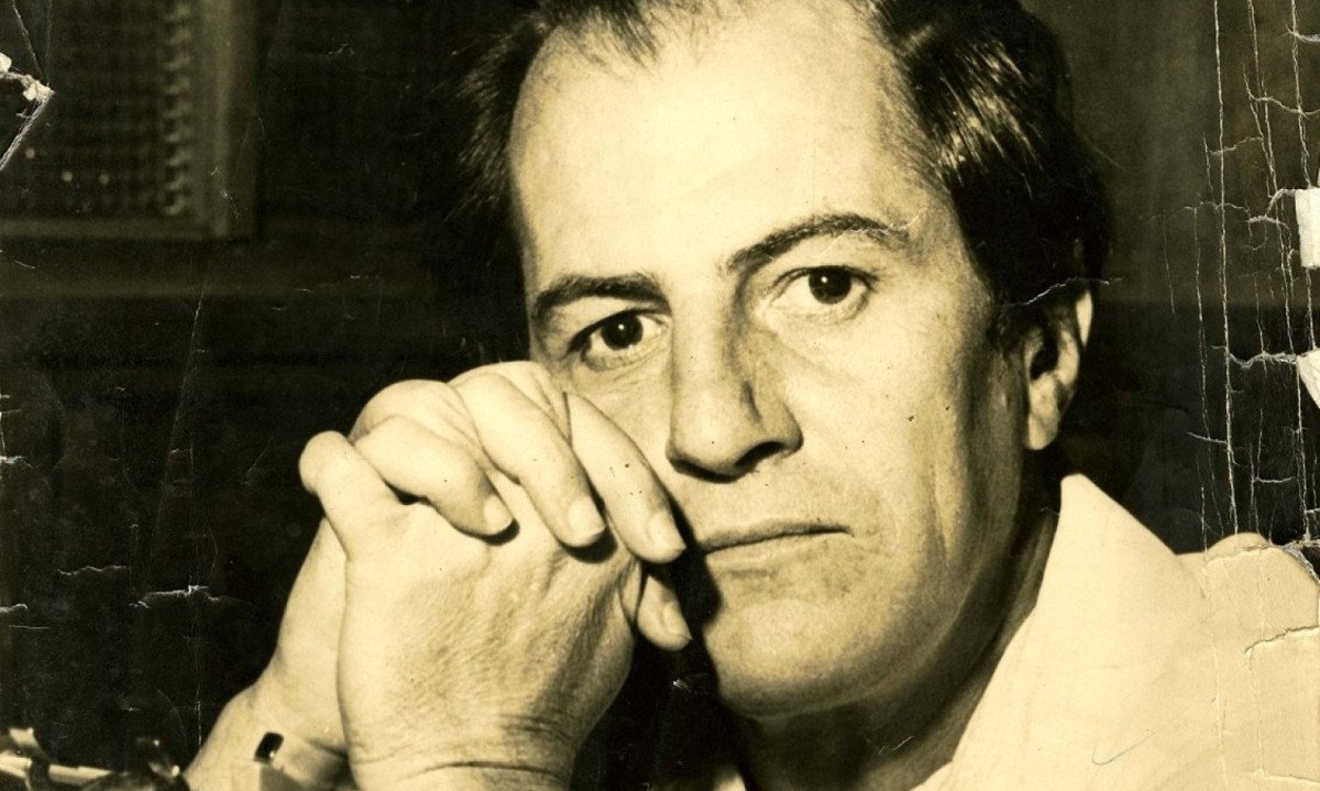 O mineiro Paulo Mendes Campos tem as m&atilde;os fechadas apoiando o rosto e olha para a c&acirc;mera