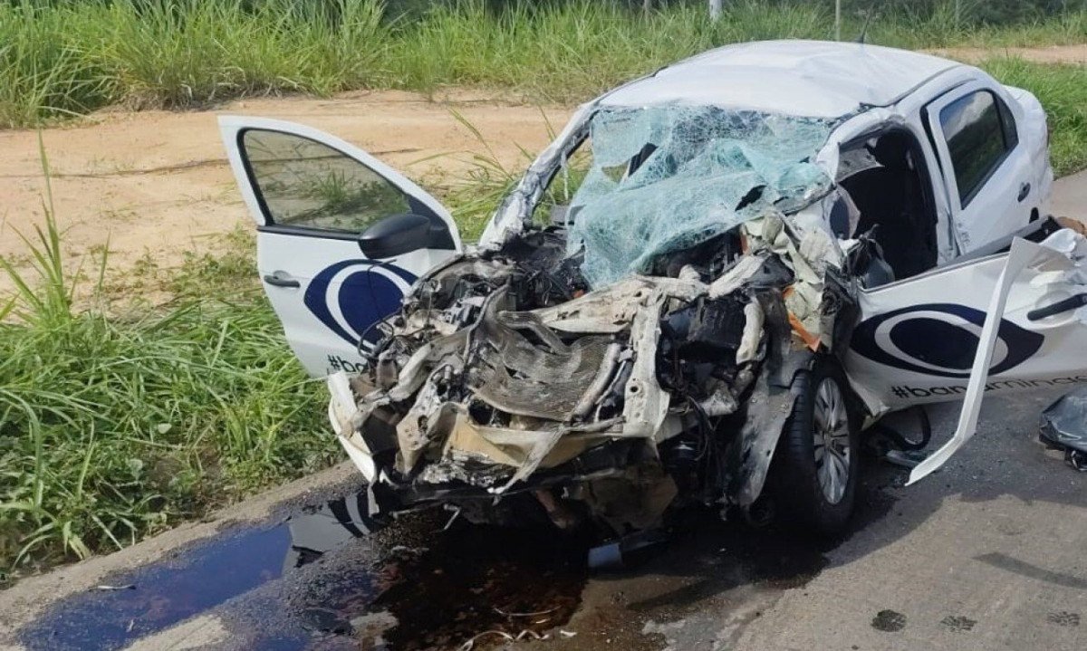 Ve&iacute;culo da cor branca ao centro da imagem, com a parte da frete do carro completamente destru&iacute;da em decorr&ecirc;ncia do acidente 