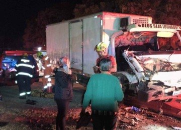 Caminh&atilde;o ficou com a parte frontal destru&iacute;da ao bater em uma carreta. O passageiro de 26 anos ficou preso nas ferragens da cabine e o motorista saiu ferido -  (crédito: CBMMG)