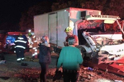 Caminh&atilde;o ficou com a parte frontal destru&iacute;da ao bater em uma carreta. O passageiro de 26 anos ficou preso nas ferragens da cabine e o motorista saiu ferido -  (crédito: CBMMG)