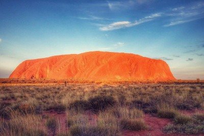 Uluru, também conhecido como Ayers Rock, é um dos maiores monólitos do mundo e um dos principais símbolos naturais da Austrália. Localizado no coração do deserto do Território do Norte, destaca-se pela imponência e pelas mudanças de cor ao longo do dia. A formação rochosa atrai cerca de 250 mil visitantes por ano, interessados em sua beleza singular e significado cultural. Mais do que um ponto turístico, Uluru é um local sagrado para os povos aborígenes Anangu, que o veem como parte viva de sua  -  (crédito: Hardlinerr -  wikimedia commons)
