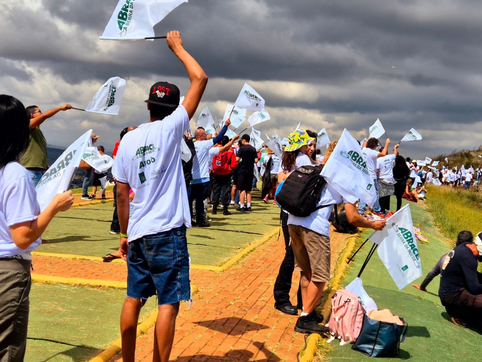 Vestidos com camisetas brancas, os participantes formaram um cord&atilde;o humano no ponto mais alto da serra e estenderam uma grande bandeira