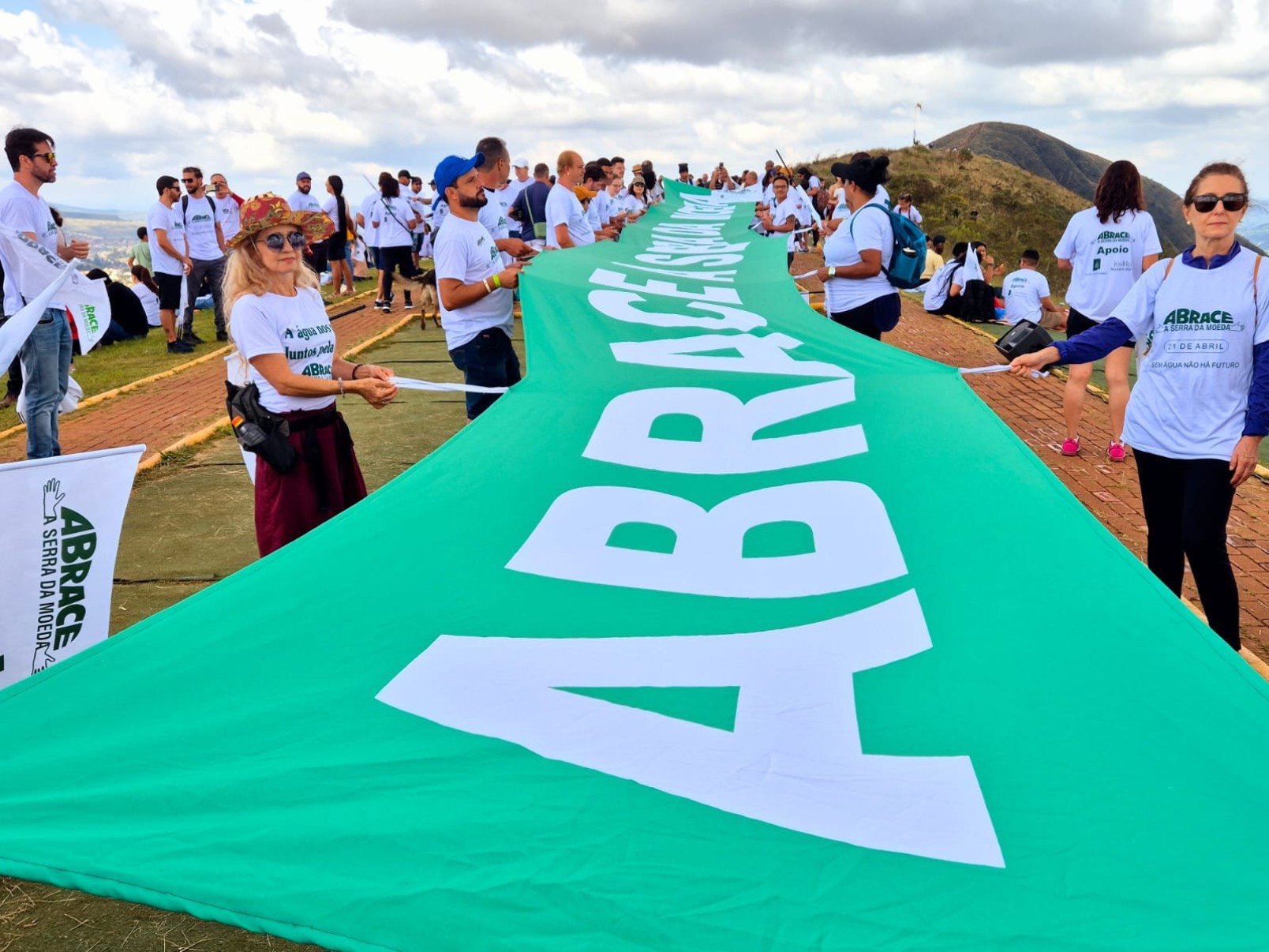Vestidos com camisetas brancas, os participantes formaram um cord&atilde;o humano no ponto mais alto da serra e estenderam uma grande bandeira