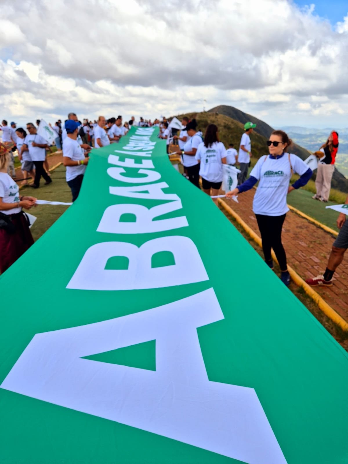 Vestidos com camisetas brancas, os participantes formaram um cord&atilde;o humano no ponto mais alto da serra e estenderam uma grande bandeira