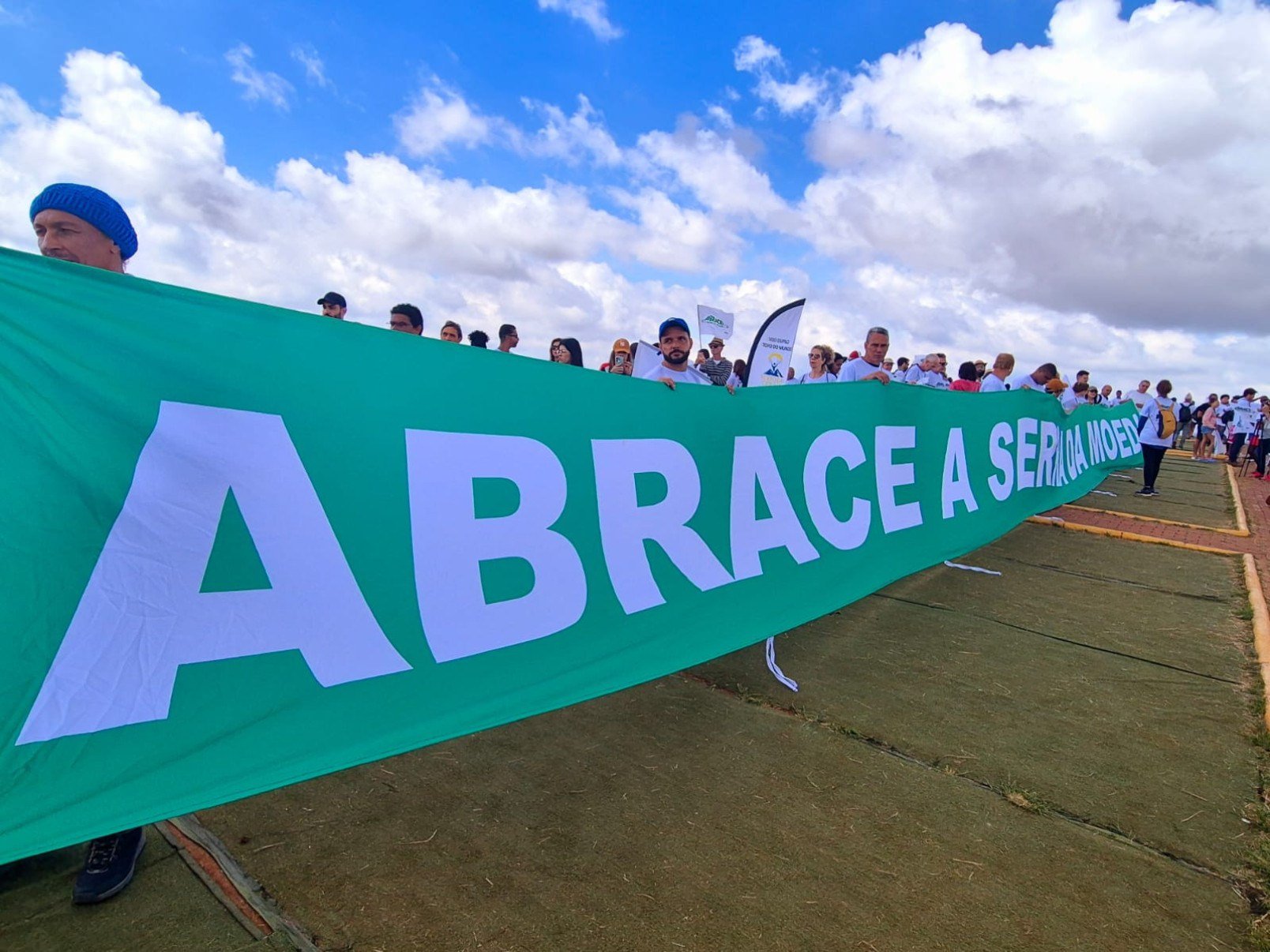 Vestidos com camisetas brancas, os participantes formaram um cord&atilde;o humano no ponto mais alto da serra e estenderam uma grande bandeira