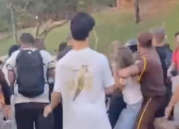 Confusão entre estudantes e bolsonaristas na UFMG. De branco, segurada por um segurança, aparece a pré-candidata Marília Amaral -  (crédito: Instagram/Reprodução)